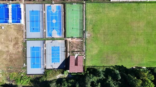Aerial View of Sports Facilities Featuring Basketball and Tennis Courts in a Sunny Outdoor Setting