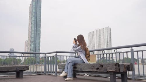 Asian woman traveler use camera taking a photo while traveling in city.