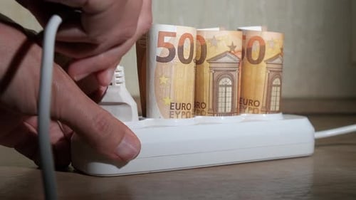 Euro Currency Bills Inserted Into Power Strip