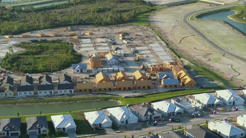 View From Above of Unfinished Frames of Inexpensive Homes with Wooden Roof Beams Under Construction