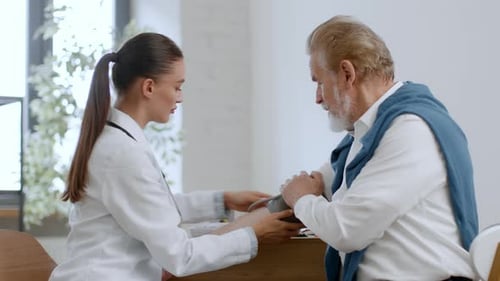Doctor Checking Senior Man's Blood Pressure in Office