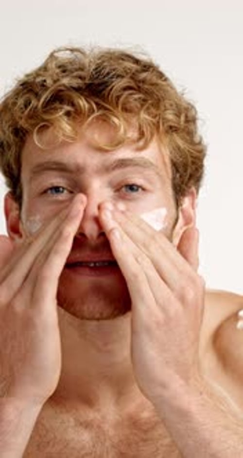 Man, lotion and skincare for face in studio with application, cosmetics