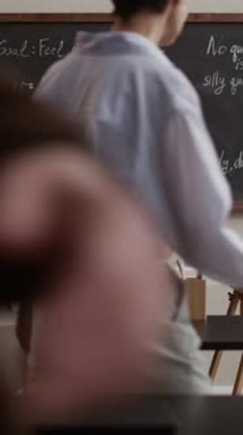 Teacher Explains Lesson to Students in Classroom