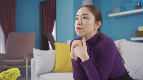 Worried Woman Sitting on Couch Looking Pensive