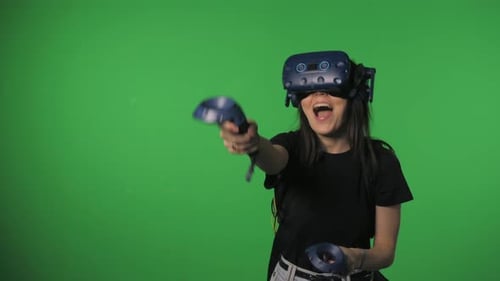 Concepto de Vídeo de realidad virtual Una mujer con unos auriculares especiales para realidad virtual con joysticks