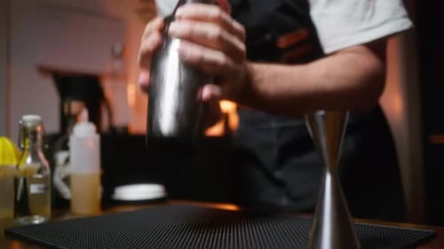 Bartender shaking cold shaker. Crafting cocktails in home bar setting. Perfect for cocktail recipes