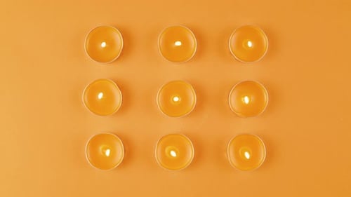 Duftkerzen auf orangefarbenem Hintergrund, Nahaufnahme von oben, Zoom, Sommer, helle Textur, Studioaufnahme für Spa