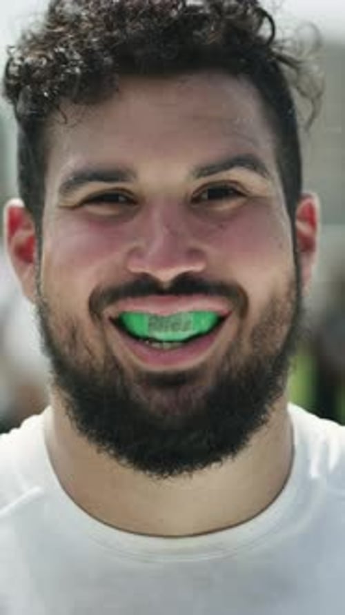Face, rugby and happy man at pitch for sports, safety and game training with mouthguard on break