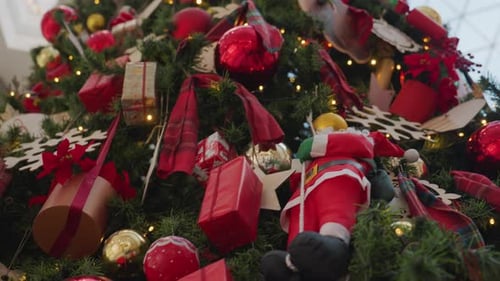 CloseUp of Festive Christmas Tree with Santa Figurine and Holiday Ornaments