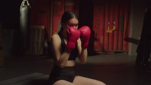 Woman Boxer Training in Dark Urban Gym