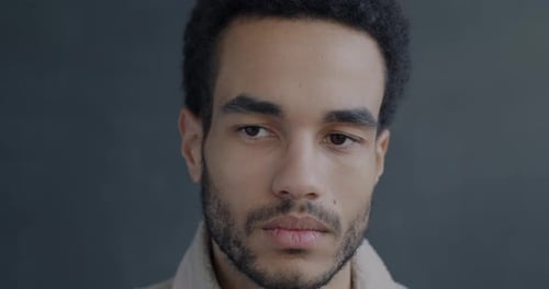 Closeup Portrait of Sad and Gloomy African American Man Looking at Camera