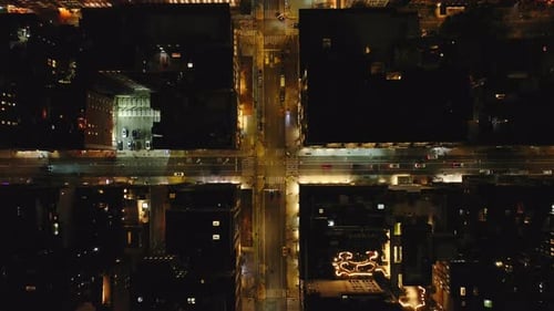 Brightly Lit Intersections in Manhattan New York City Come Alive at Night with Iconic Cabs and Cars