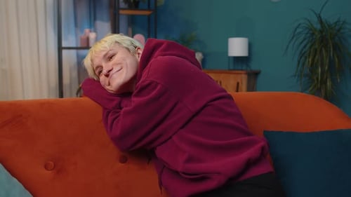 Smiling Woman Relaxing on a Red Sofa