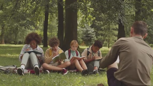 Teacher and School Kids Having Outdoor Lesson in Park