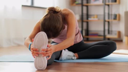 Woman Stretching Legs Reaching Toes Indoors