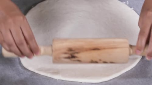 Hands Roll Out Dough for Baking