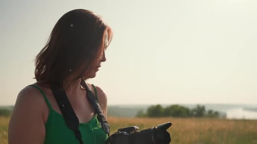 Female Photographer Removing Lens Cover in Sunny Grassy Field