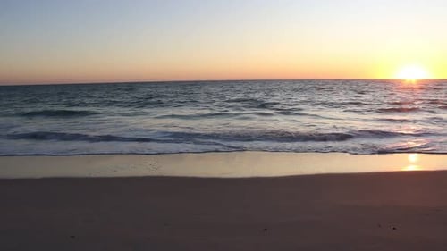 Beautiful golden hour scenery. Tranquil ocean water. Panning right