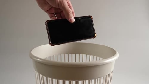 55. An old broken smartphone is thrown into the trash for recycling