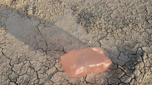 Una bolsa de plástico vuela en tierra seca: desastre ambiental