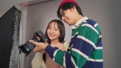 Asian beautiful woman model and cameraman working in photography studio.