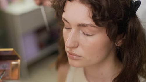 Woman Applies Makeup with Brush Close Up