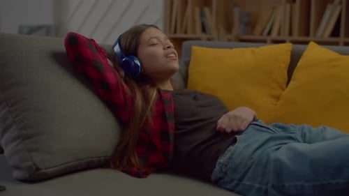 Child Listening to Music on Couch Relaxing