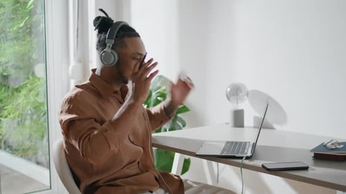 Man with Headphones Video Conferencing at Home