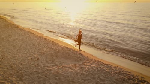 Aerial Shot Fit Slim Woman Jogging on Beach at Sunset Girl with Yoga Mat Running Barefoot