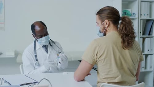 Doctor Prepares Vaccine with Patient in Office