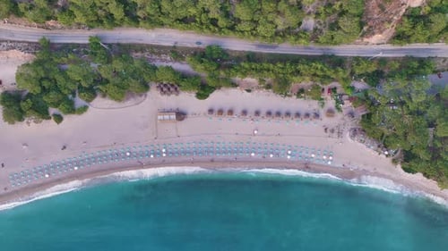 Turquoise Waves Gently Caress the Sandy Shore of a Picturesque Beach Resort Where Rows of Beach