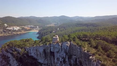 Watchtower on a cliff at rocky mountains. Port de Sant Miquel, Ibiza, Spain.