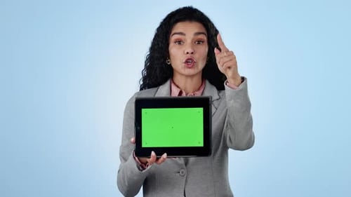 Green screen, smile and a business woman pointing at a tablet on a blue background in studio