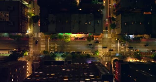 Beautifully lit streets of night New York. Lots of cars going along the roads and passing crossroads