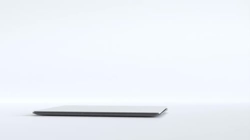 Laptop with Green Screen Display on White Surface