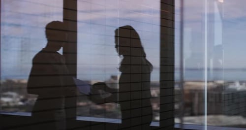 Business people, window and discussion with documents at office for interview, planning or proposal