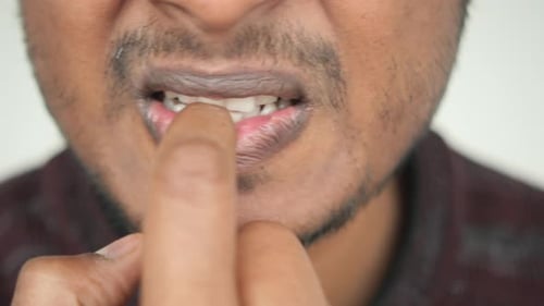 Adult Bites Fingernail in Extreme Close Up