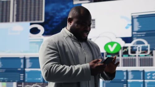 Enthusiastic Businessman Using Phone in Tech Office