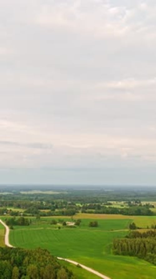 Panorama Of Green Fields, Road, And Bright Sky In Daytime. - aerial vertical shot