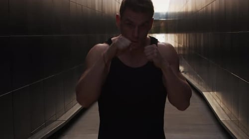 Man Shadow Boxing in an Urban Walkway