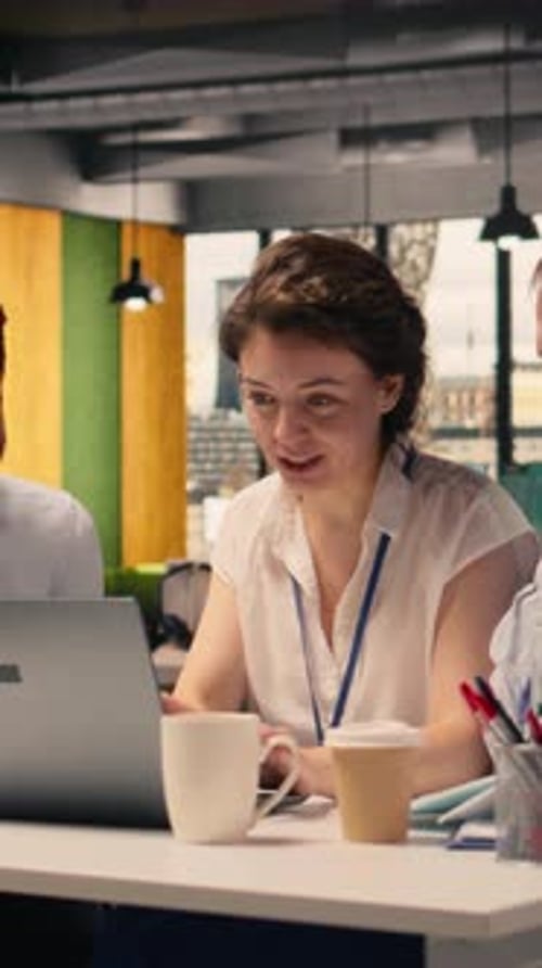 Vertical Video Team Collaboration in a Corporate Office Environment with Laptop and Reports