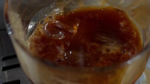 Making Refreshing Iced Coffee Drink with Ice Cubes