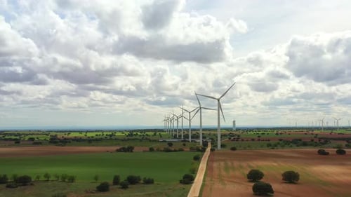 Wind Turbine Spinning Over Green Farmland Under Sky
