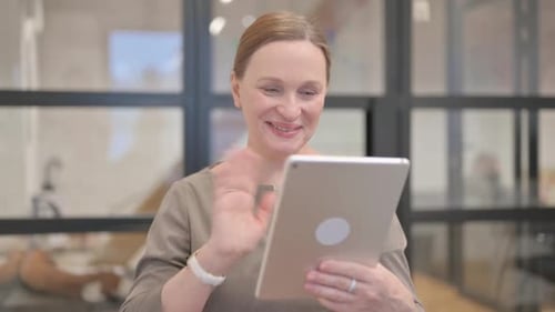 Woman on Tablet Waving in Modern Office
