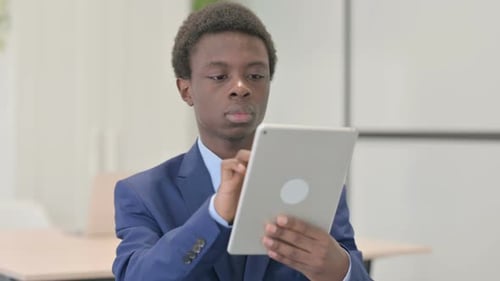 Young Adult in Suit Using Tablet in Office