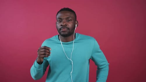 Young Adult Puts in Headphones and Uses Phone