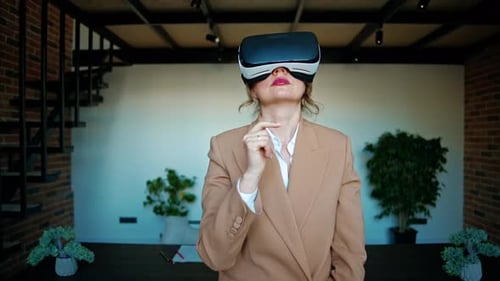 Woman gesturing while using a Virtual Reality headset in an office