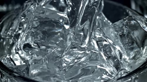 Water Pouring Over Ice Cubes in Glass