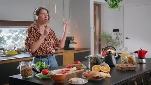 Woman Dancing and Singing in Kitchen While Cooking