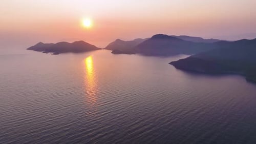 Warm Sunlight Illuminates the Tranquil Ocean Surface Creating a Shimmering Path Towards the Setting